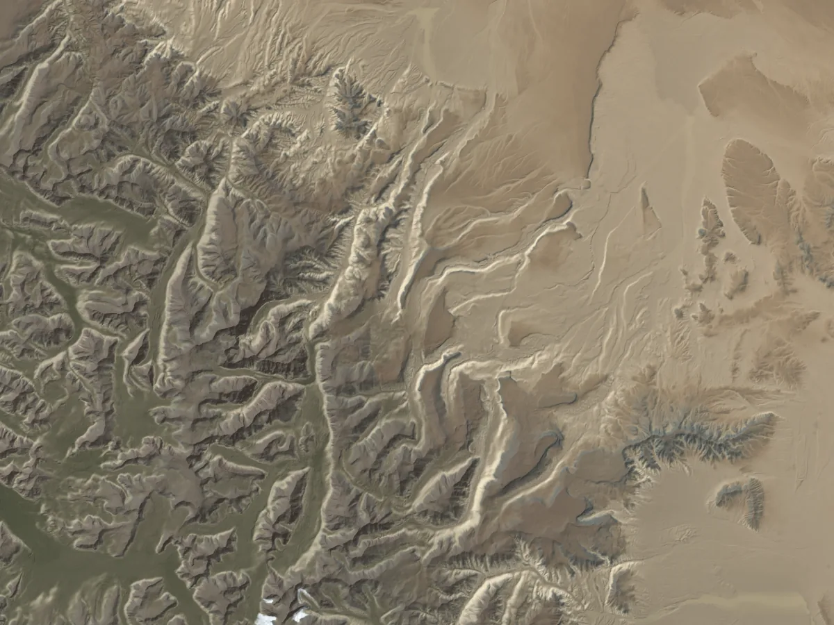 A deeply dissected range shedding alluvial fans onto a pale basin