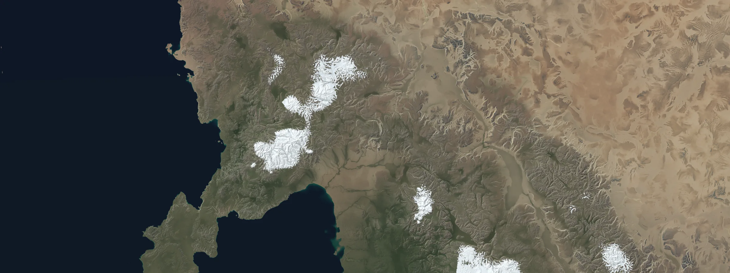 A 1183 km band across the section, with a desert erg in the north, snow-capped fold ranges, and a coast with islands to the west